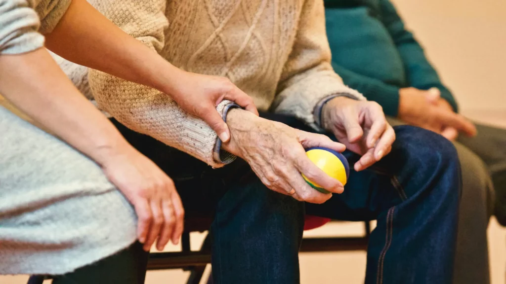 personne âgée tenant une balle